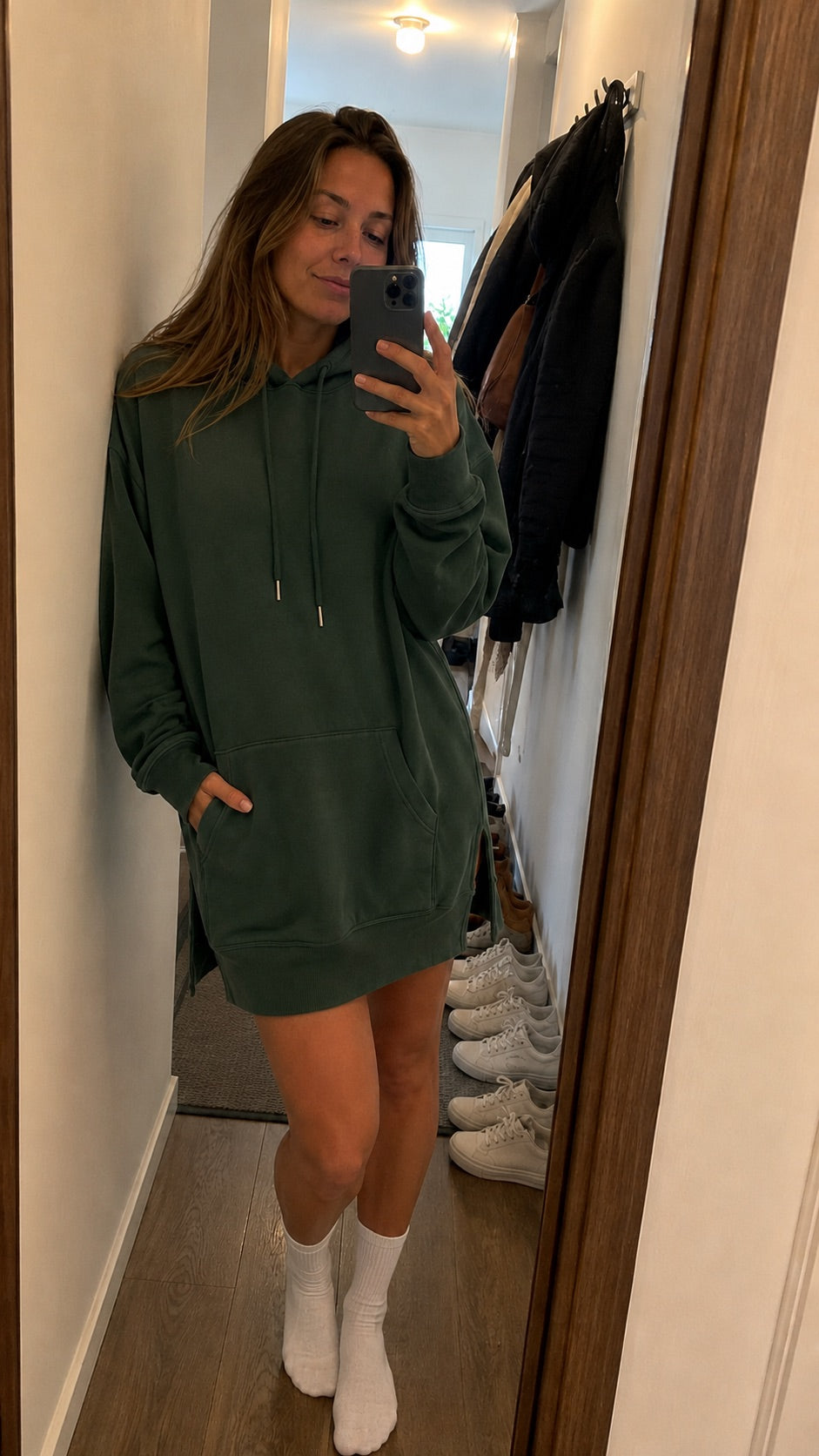 Woman wearing a Warmy hoodie dress in her hallway