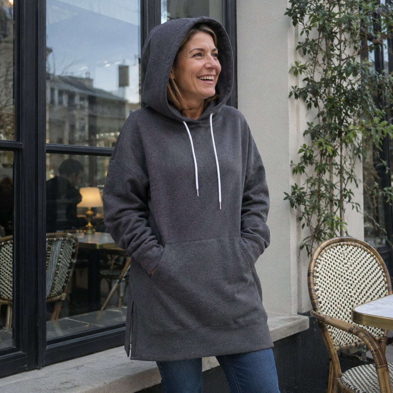 Woman outdoors with her hood up and both hands in the front pocket
