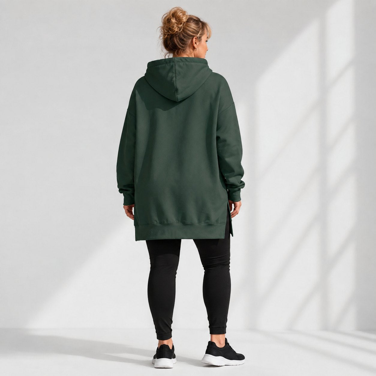Rear view of the green Warmy showing the longer hem over leggings